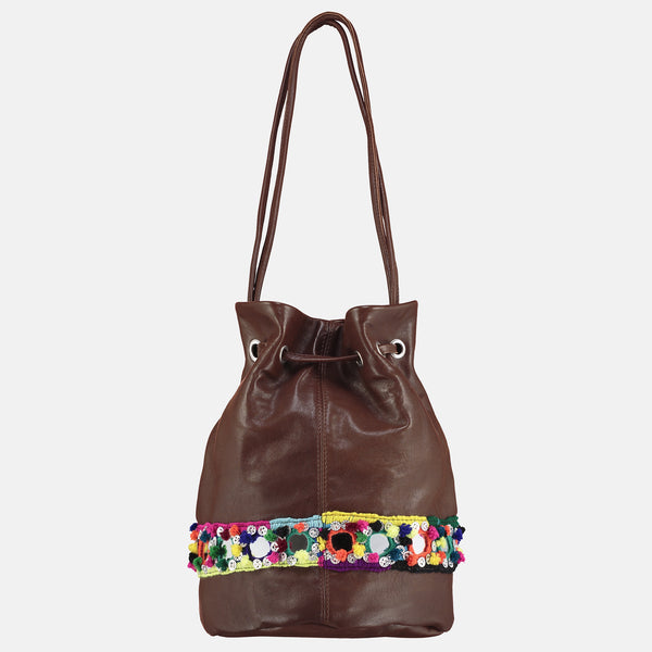 small veg tan leather bucket bag with mirror handwork tribal detail bright pompoms . rear view