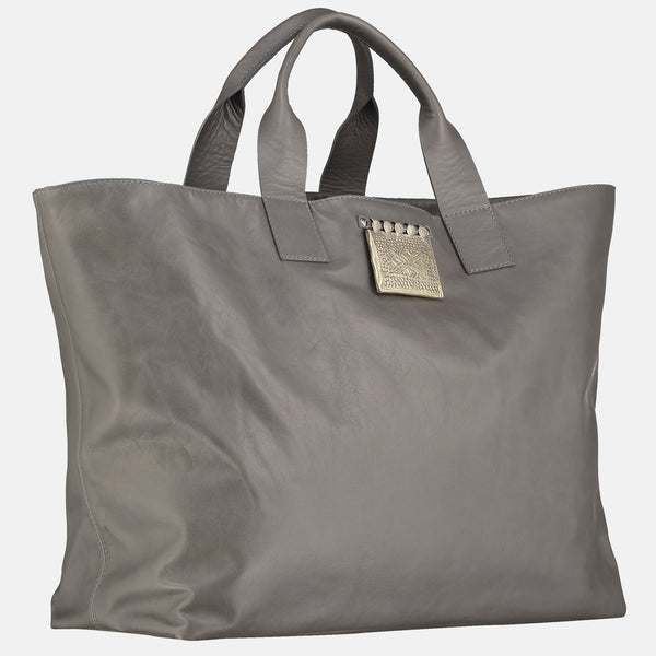 grey italian leather handmade travel bag. leather tote , side view , silver colour tribal pendant detail